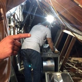 Technician pointing to an HVAC install