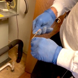 Tech is cleaning a customer's flame sensor